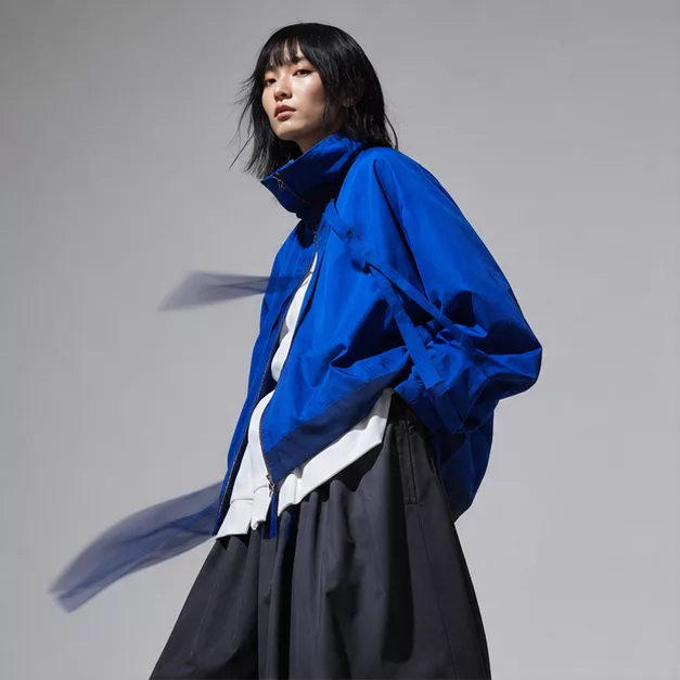 Model in a cobalt jacket, profile view.